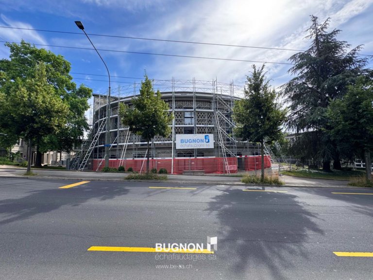 Université Magna entouré des échafaudages avec vue sur les arbres et le trottoir